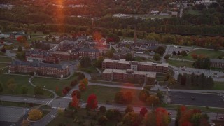 AX149_230E - 5.5K aerial stock footage orbiting Maine government offices, colorful trees, autumn, Augusta, Maine, twilight