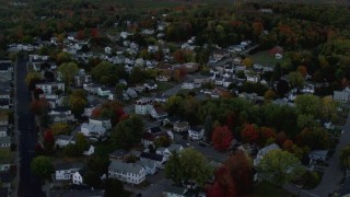 AX149_238 - 5.5K aerial stock footage flying over neighborhood  and colorful foliage in autumn, Augusta, Maine, twilight