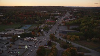 AX149_254E - 5.5K aerial stock footage of a Western Avenue strip mall in autumn, Augusta, Maine, twilight