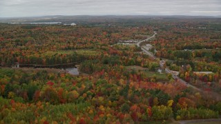 AX150_002 - 5.5K aerial stock footage flying over forest, reveal cemetery, Western Avenue, autumn, Manchester, Maine