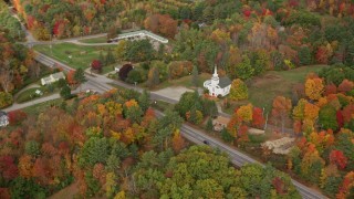 AX150_008E - 5.5K aerial stock footage flying by East Winthrop Baptist Church, Western Avenue, autumn, Winthrop, Maine