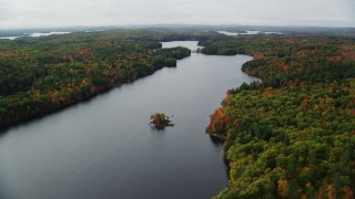 AX150_012 - 5.5K aerial stock footage flying by Upper Narrows Pond, forest of colorful trees, autumn, Winthrop, Maine