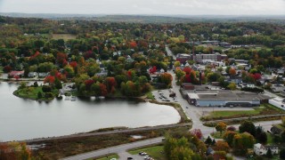 AX150_018 - 5.5K aerial stock footage orbiting homes and small town near water, autumn, Winthrop, Maine