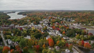 AX150_020E - 5.5K aerial stock footage flying over small town, homes, factory, roads, autumn, Winthrop, Maine