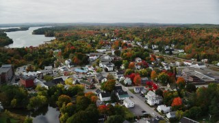 AX150_021 - 5.5K aerial stock footage flying over small town homes, Main Street, tilt down, autumn, Winthrop, Maine