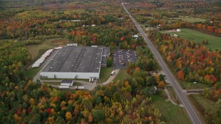 AX150_025 - 5.5K aerial stock footage approaching a warehouse off Route 11, tilt down to bird's eye view, autumn, Winthrop, Maine