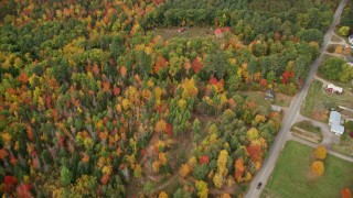 AX150_029E - 5.5K aerial stock footage of a bird's eye view over colorful forest, reveal river and rural homes, autumn, Monmouth, Maine