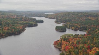 AX150_038 - 5.5K stock footage aerial video flying by Androscoggin River, colorful forest in autumn, overcast, Leeds, Maine