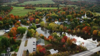 AX150_044 - 5.5K stock footage aerial video orbiting small rural town near Nezinscot in autumn, Turner, Maine