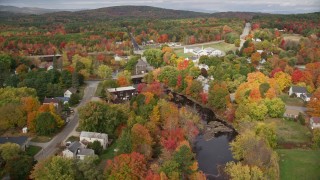 AX150_048E - 5.5K aerial stock footage a small rural town, bridges spanning Nezinscot River, autumn, Turner, Maine