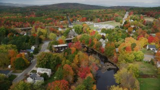AX150_049 - 5.5K stock footage aerial video orbiting small rural town, bridges spanning Nezinscot River, autumn, Turner, Maine