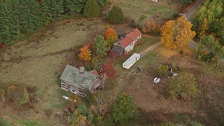 AX150_053 - 5.5K aerial stock footage flying by an old barn, colorful foliage in autumn, Turner, Maine