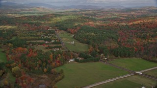 AX150_056E - 5.5K aerial stock footage flying by colorful first, Turner Street, rural homes, autumn, Buckfield, Maine