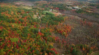 AX150_061 - 5.5K aerial stock footage flying over colorful forest, rural homes, Sodom Road, autumn, Buckfield, Maine