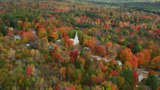 AX150_063 - 5.5K aerial stock footage flying by Union Church, small town, colorful trees in autumn, Buckfield, Maine