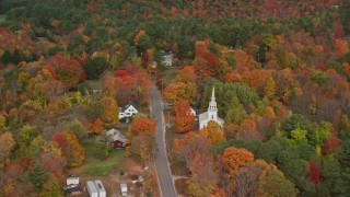 AX150_063E - 5.5K aerial stock footage flying by Union Church, small town, colorful trees in autumn, Buckfield, Maine