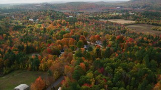 AX150_066 - 5.5K aerial stock footage orbiting rural homes, small town, colorful foliage, autumn, Buckfield, Maine