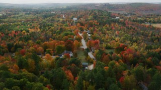 AX150_067 - 5.5K aerial stock footage flying over small town, rural homes and Union Church, autumn, Buckfield, Maine
