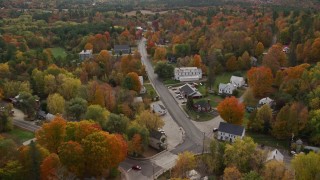 AX150_067E - 5.5K aerial stock footage flying over small town, rural homes and Union Church, autumn, Buckfield, Maine