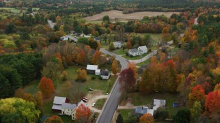 AX150_070 - 5.5K aerial stock footage flying over small town, rural homes, Turner Street, colorful trees, autumn, Buckfield, Maine