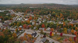 AX150_082E - 5.5K aerial stock footage flying over forest and Little Androscoggin River, approach small rural town, autumn, Paris, Maine