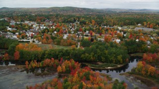 AX150_083 - 5.5K aerial stock footage flying over Little Androscoggin River, approach small rural town, autumn, Paris, Maine