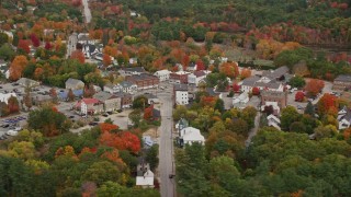AX150_087E - 5.5K aerial stock footage orbiting small rural town with colorful foliage, autumn, Paris, Maine