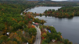 AX150_099 - 5.5K aerial stock footage flying over Lake Road, Pennesseewassee Lake, autumn, Norway, Maine