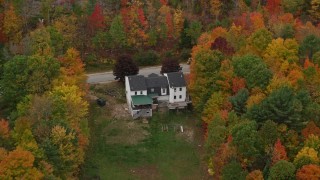 AX150_102 - 5.5K aerial stock footage flying by an isolated home, colorful trees, tilt down, autumn, Norway, Maine