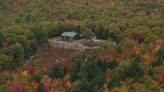 AX150_106 - 5.5K aerial stock footage flying by isolated hilltop home, colorful trees in autumn, Norway, Maine