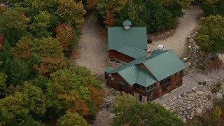 AX150_107 - 5.5K aerial stock footage flying by isolated home on a hilltop, colorful trees in autumn,  Norway, Maine