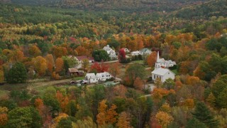 AX150_119E - 5.5K aerial stock footage orbiting a small rural town, revealing a church, autumn, Waterford, Maine