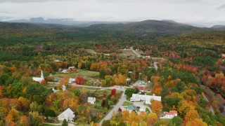 AX150_122 - 5.5K stock footage aerial video orbiting colorful foliage, small town, autumn, Waterford, Maine