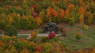 AX150_125 - 5.5K aerial stock footage flying by an isolated rural home, colorful forest, autumn, Waterford, Maine