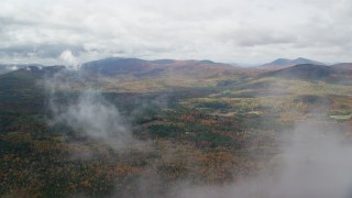 AX150_147 - 5.5K aerial stock footage flying over forest, through clouds, reveal White Mountains, autumn, New Hampshire