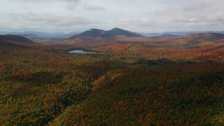 AX150_151 - 5.5K aerial stock footage flying over forest, approaching Mountain Pond, White Mountains, New Hampshire