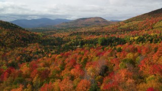 AX150_160 - 5.5K aerial stock footage flying over colorful forest, autumn, approach clouds, White Mountains, New Hampshire