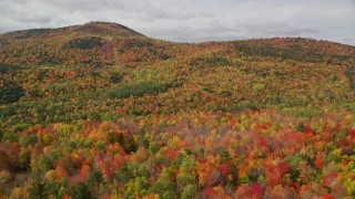 AX150_164 - 5.5K aerial stock footage flying over colorful forest, approaching cloudy skies, White Mountains, New Hampshire