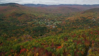 AX150_170 - 5.5K aerial stock footage flying over bright forest, approaching small town of Jackson, New Hampshire