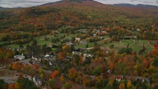 AX150_170E - 5.5K aerial stock footage approach and flyby a small rural town and Wentworth Golf Club, autumn, Jackson, New Hampshire