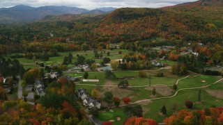 AX150_173 - 5.5K aerial stock footage orbiting a small rural town, Wentworth Golf Club, autumn, Jackson, New Hampshire