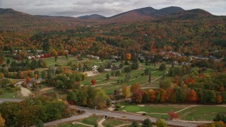 AX150_174E - 5.5K aerial stock footage orbiting small rural town, Wentworth Golf Club, autumn, cloudy, Jackson, New Hampshire