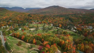 AX150_177 - 5.5K aerial stock footage flying by small rural town, Wentworth Golf Club, trees, autumn, Jackson, New Hampshire