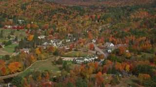AX150_178E - 5.5K aerial stock footage orbiting a small rural town, colorful foliage, autumn, Jackson, New Hampshire