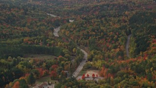 AX150_182 - 5.5K aerial stock footage flying by Route 16, brightly colored forest in autumn, Jackson, New Hampshire