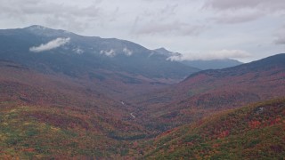 AX150_184 - 5.5K aerial stock footage flying by Mount Washington, overcast, forest, autumn, White Mountains, New Hampshire