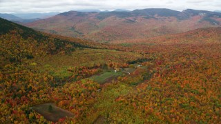 AX150_185 - 5.5K aerial stock footage approaching an isolated home, forest, tilt down, autumn, White Mountains, New Hampshire