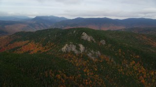 AX150_192 - 5.5K aerial stock footage flying by forest, Stairs Mountain, overcast, autumn, White Mountains, New Hampshire