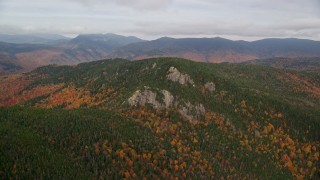 AX150_192E - 5.5K aerial stock footage flying by forest, Stairs Mountain, overcast, autumn, White Mountains, New Hampshire