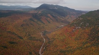 AX150_194E - 5.5K aerial stock footage of Highway 302, forest, Mount Willey, autumn, rainy, White Mountains, New Hampshire